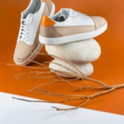 Brown and off-white sneakers — back view on rocks (thumbnail)